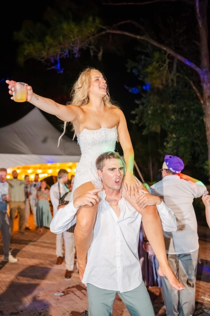 Emily sits on Aaron's shoulders while singing along to Toby Keith during their Lakeview Gardens wedding reception.