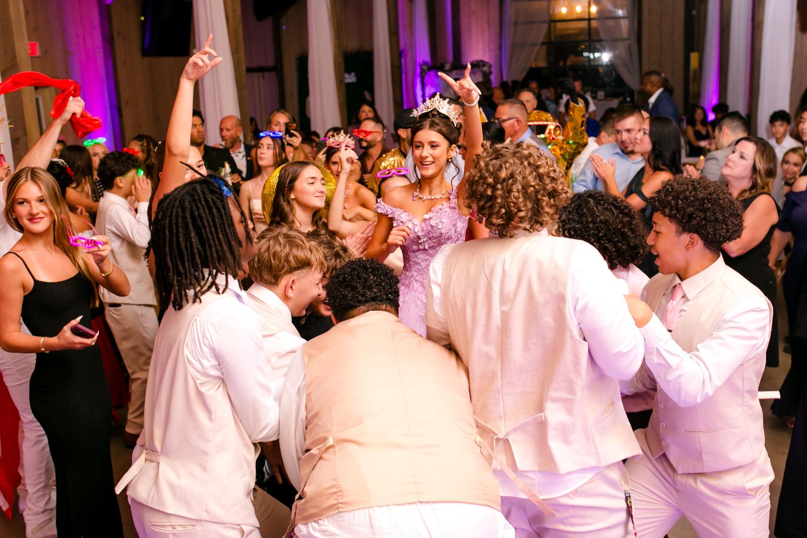 Parent dancing with one of the quinceañera twins during a formal dance at The Barn at Hidden Oaks Farm.