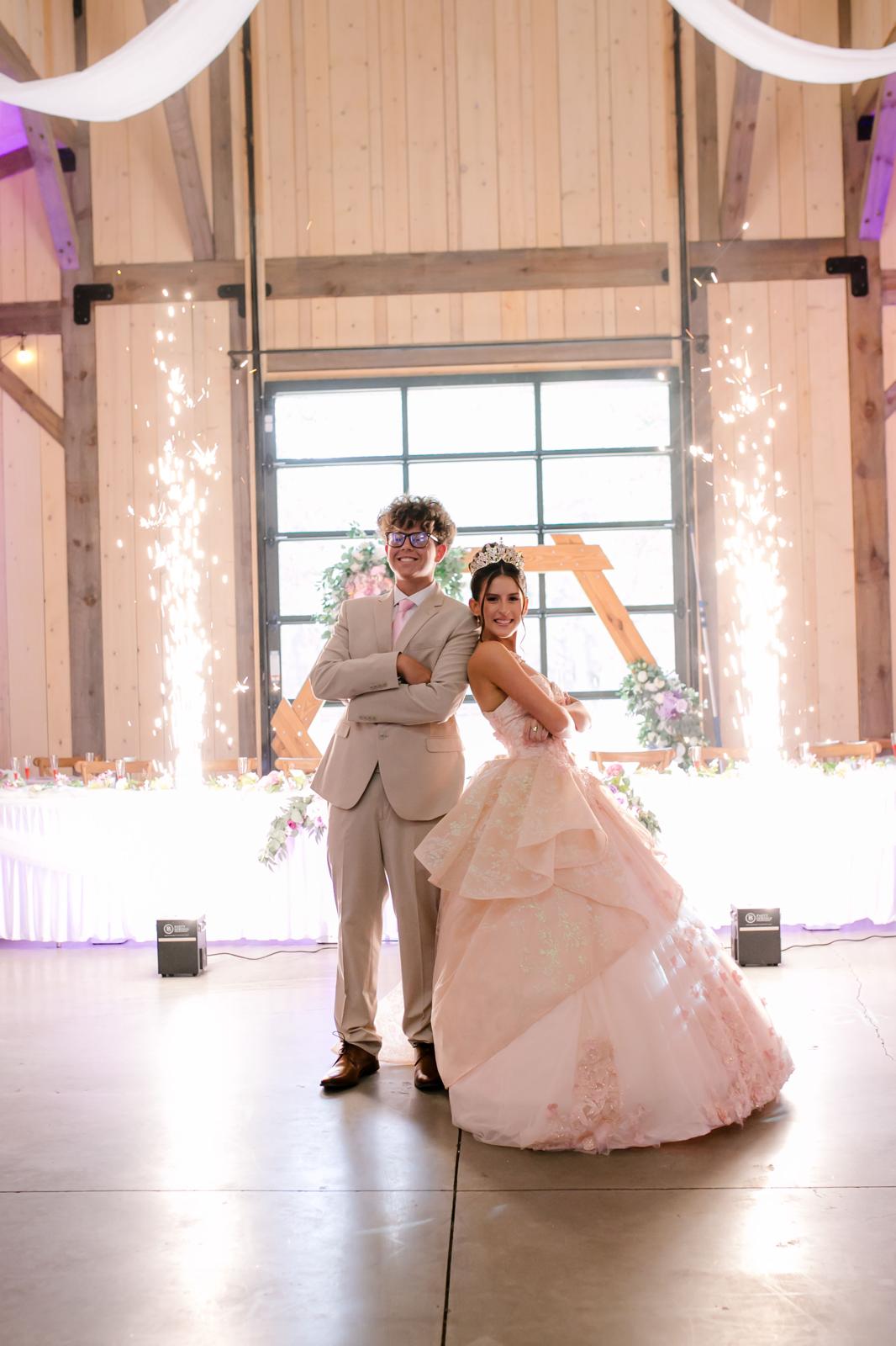 Alaina entering her quinceañera separately as cold spark fountains fire at The Barn at Hidden Oaks Farm.