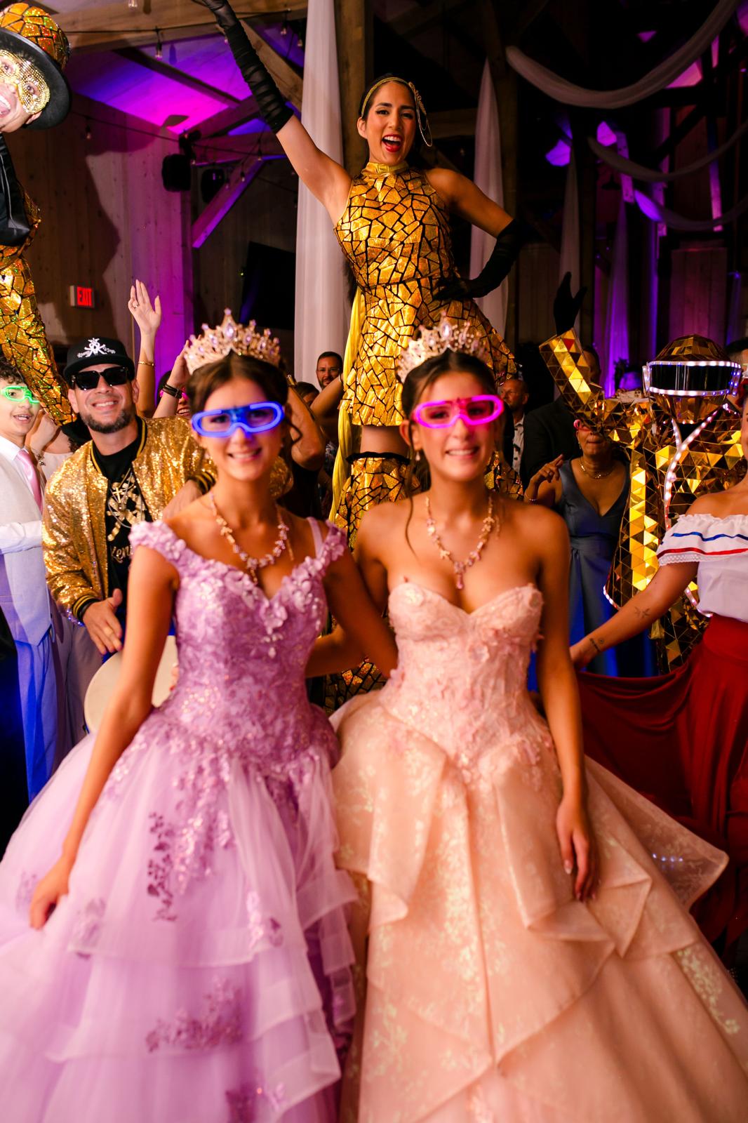 Alaina and London dancing with gold-costumed Hora Loca performers at their quinceañera.