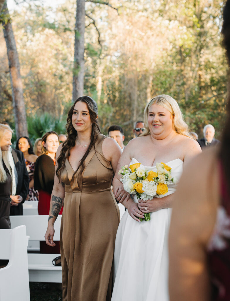 Bride Sydney walking down the aisle with her bridesmaid at The Farmhouse on 44.