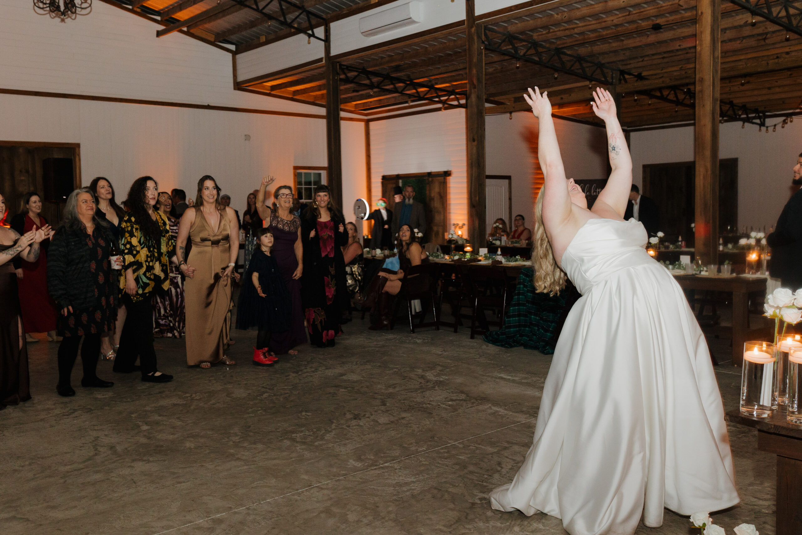 Sydney throwing her bouquet during her Farmhouse on 44 wedding reception in Central Florida.