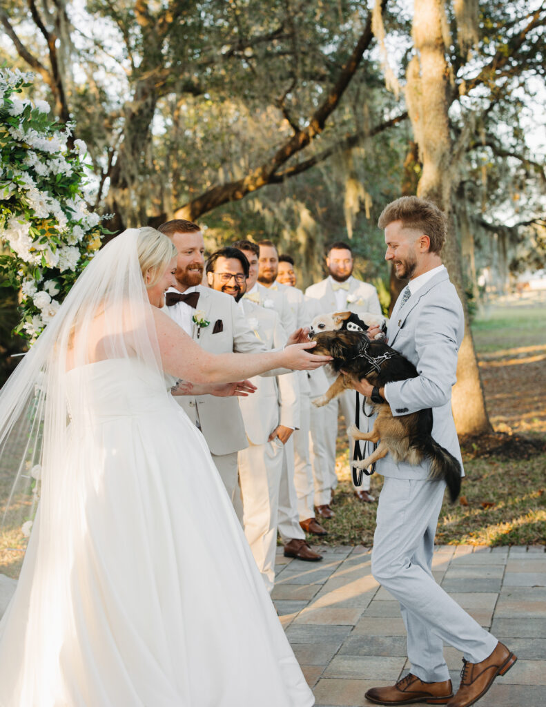 Sydney and Travis sharing a joyful moment during their outdoor wedding ceremony at The Farmhouse on 44.