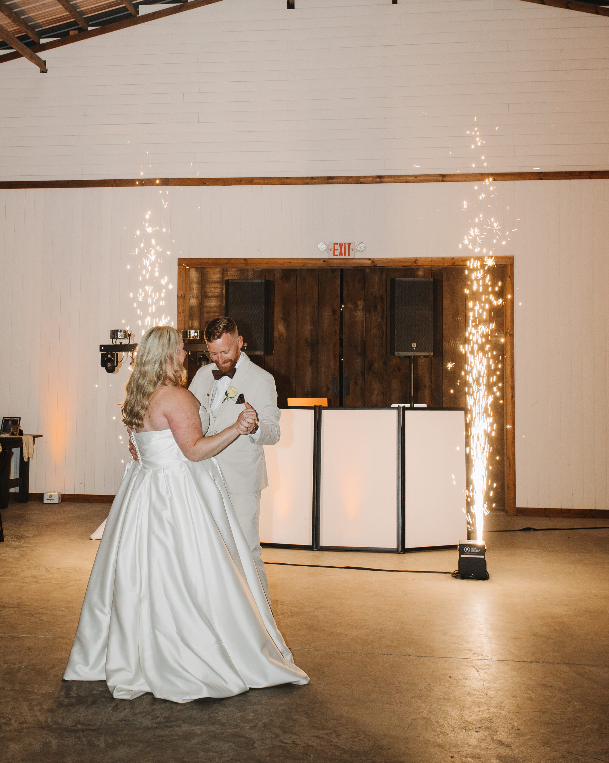 Travis and Sydney sharing their first dance surrounded by cold spark fountains at their wedding reception.