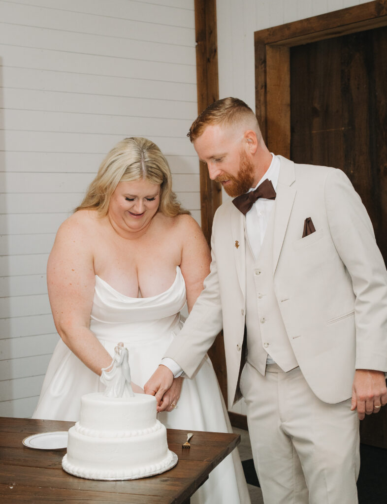 Travis and Sydney cutting their wedding cake together during their reception.