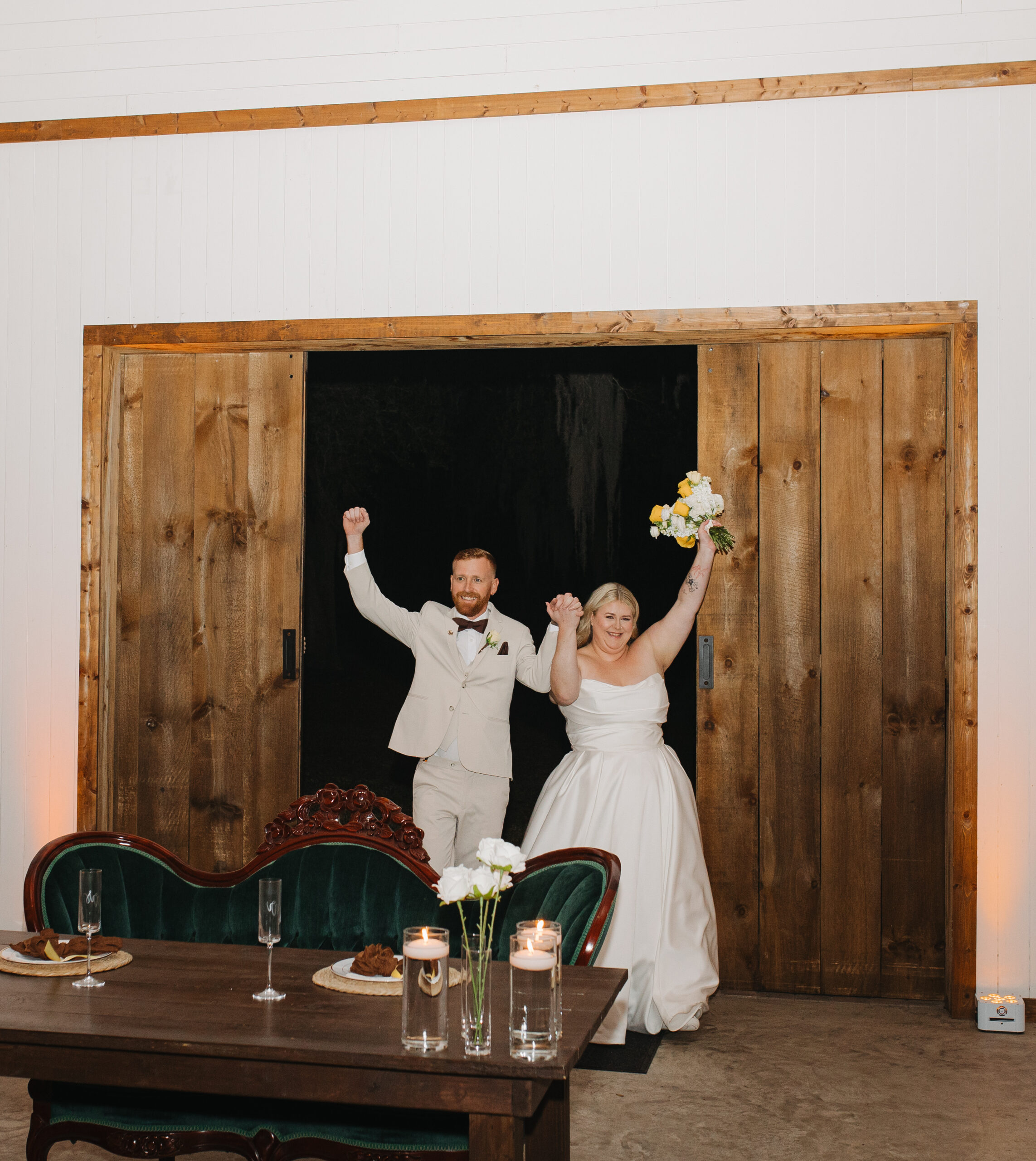 Travis and Sydney celebrating together as they enter their wedding reception at The Farmhouse on 44.
