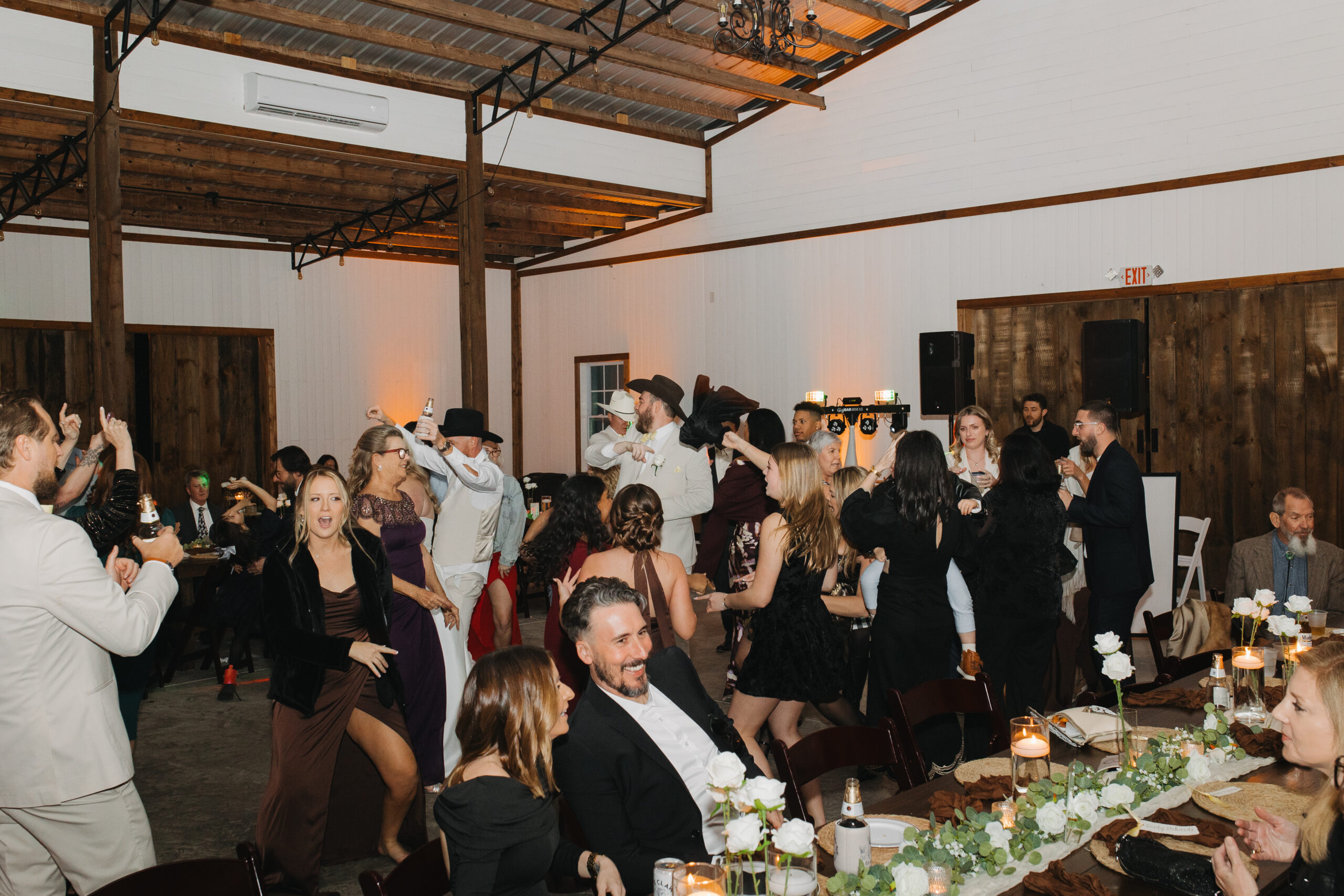 Wedding guests filling the dance floor during Travis and Sydney’s reception at The Farmhouse on 44.