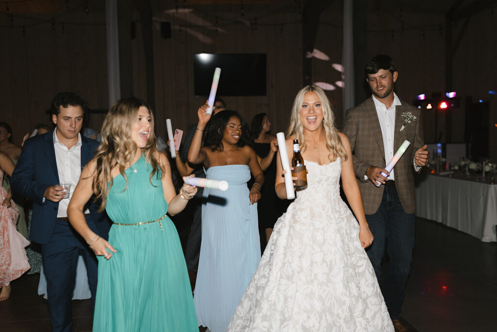 Bride dancing with glow sticks during The Barn at Hidden Oaks reception