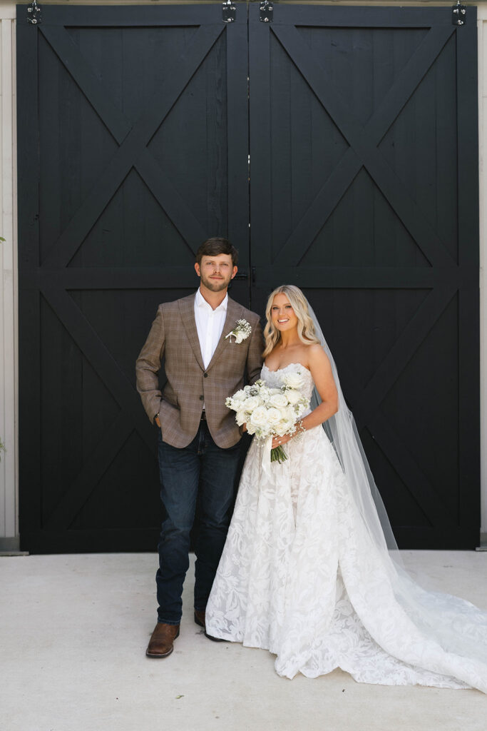 Bride and groom portrait in front of the black barn doors at The Barn at Hidden Oaks