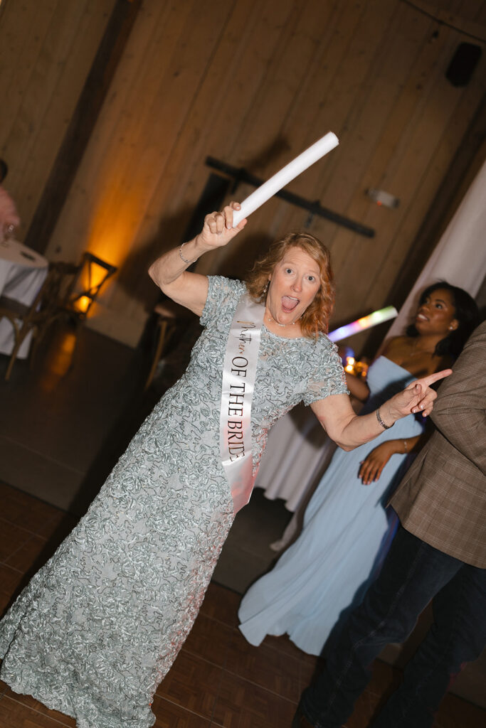 Wedding guest dancing with glow sticks at The Barn at Hidden Oaks